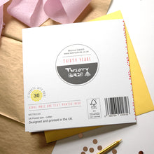 Load image into Gallery viewer, Back of a card with branding and product details on a surface with ribbons and a candle.