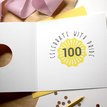 Load image into Gallery viewer, Card with &#39;Celebrate with Pride 100&#39; design on a wooden surface with decorative elements.