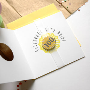 Card with 'Celebrate with Pride' 100 button badge on a white surface