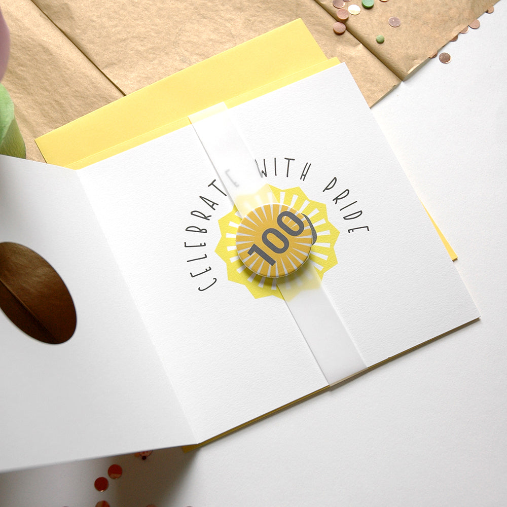 Card with 'Celebrate with Pride' 100 button badge on a white surface
