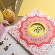Card with '30 Years of Being an Honourable Human' text on a festive background with confetti and a cupcake.