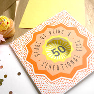 Greeting card with '50 Years of Being a Sensational Soul' text on a wooden surface with a cupcake.