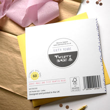 Load image into Gallery viewer, back of card with branding and design details on a wooden surface