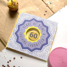Load image into Gallery viewer, 60th birthday card with decorative elements on a table