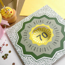 Load image into Gallery viewer, 70th birthday card with cupcake and confetti on a wooden surface