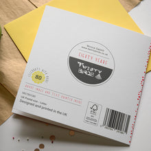 Load image into Gallery viewer, Back of card with branding and product details on a wooden surface