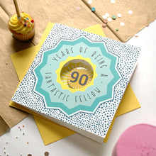 Load image into Gallery viewer, 90th birthday card with decorative elements on a table with a cupcake.