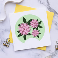 Card with pink floral design on a marble surface