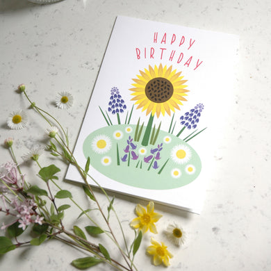 Greeting card with sunflower and floral design on a textured surface with flowers around