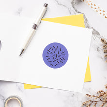 Load image into Gallery viewer, Purple circular design on a white card with yellow envelope on marble surface
