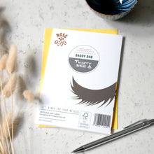 Load image into Gallery viewer, A greetings card with a dog's tail printed on the back from the 'Nose to Toes' range labeled 'Daddy Dad' by 'Twenty Birds', placed on a light marble surface with dried grass stems and a metal pen.