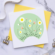 Greeting card with floral daisy design on a marble surface