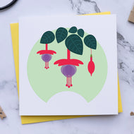 Card with fuchsia plant design on a marble surface