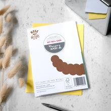Load image into Gallery viewer, A printed pet well-being card on a light marble surface, layered over a yellow envelope. The front card is white with brown paw-print graphics, a circular 'Get Well Soon' title.