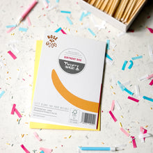 Load image into Gallery viewer, A custom printed 'Nose to toes' birthday card 'Twenty Birds' on top of a yellow envelope, styled on a white surface with colorful confetti and a box of wooden matches in the background.