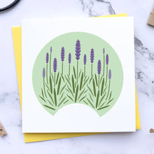 Load image into Gallery viewer, A square white card featuring a stylized illustration of lavender plants inside a pale green semicircle, layered over a yellow backing card on a white marble surface with small craft props around it.