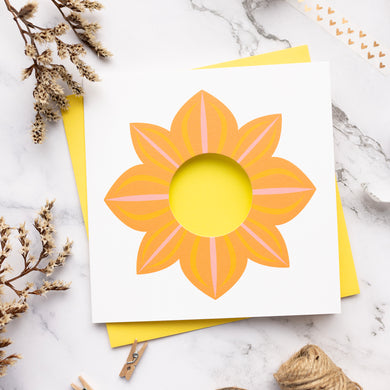 Card with an orange dahlia design on a marble surface