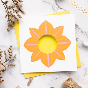 Card with an orange dahlia design on a marble surface
