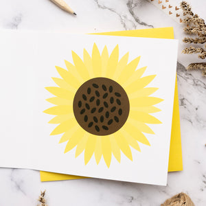 Card with a yellow sunflower design on a marble surface