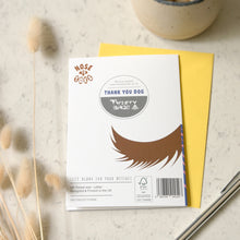 Load image into Gallery viewer, The back of a greetings card with a dogs tail printed on the bottom. The card says 'Thank you Dog' and is sat on top of a yellow envelope on a marble surface. 
