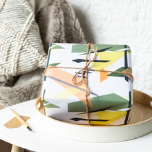 Load image into Gallery viewer, Gift wrapped in geometric pattern with brown twine on a white surface.