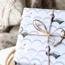 Load image into Gallery viewer, Gift wrapped in paper with black swan design, tied with twine, on a textured surface.